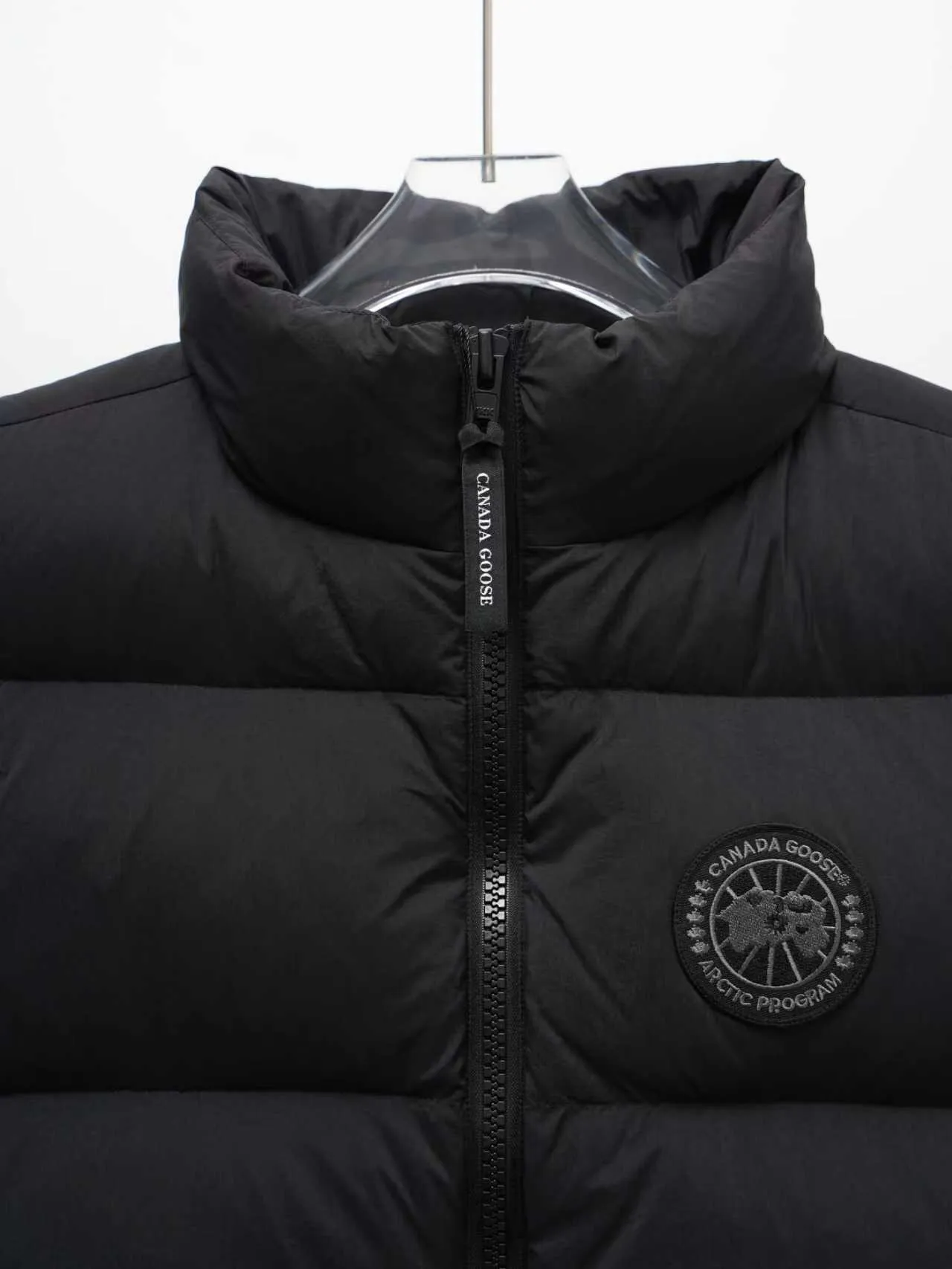 P580 Canada gooes Lawrence Down Vest (high version) With a durable shell and quilted body, the Lawrence Down Vest is a must-have for all seasons. The fabric has a durable soft touch. Longer hem at back for added protection. Reflective double-stripe grip tape at back. The Lawrence features an engineered down-filled collar to block strong winds, a two-way front zip and a longer rear hem. Color: black with red label, black with black label, desert color, ocean blue Size: XS -2XL